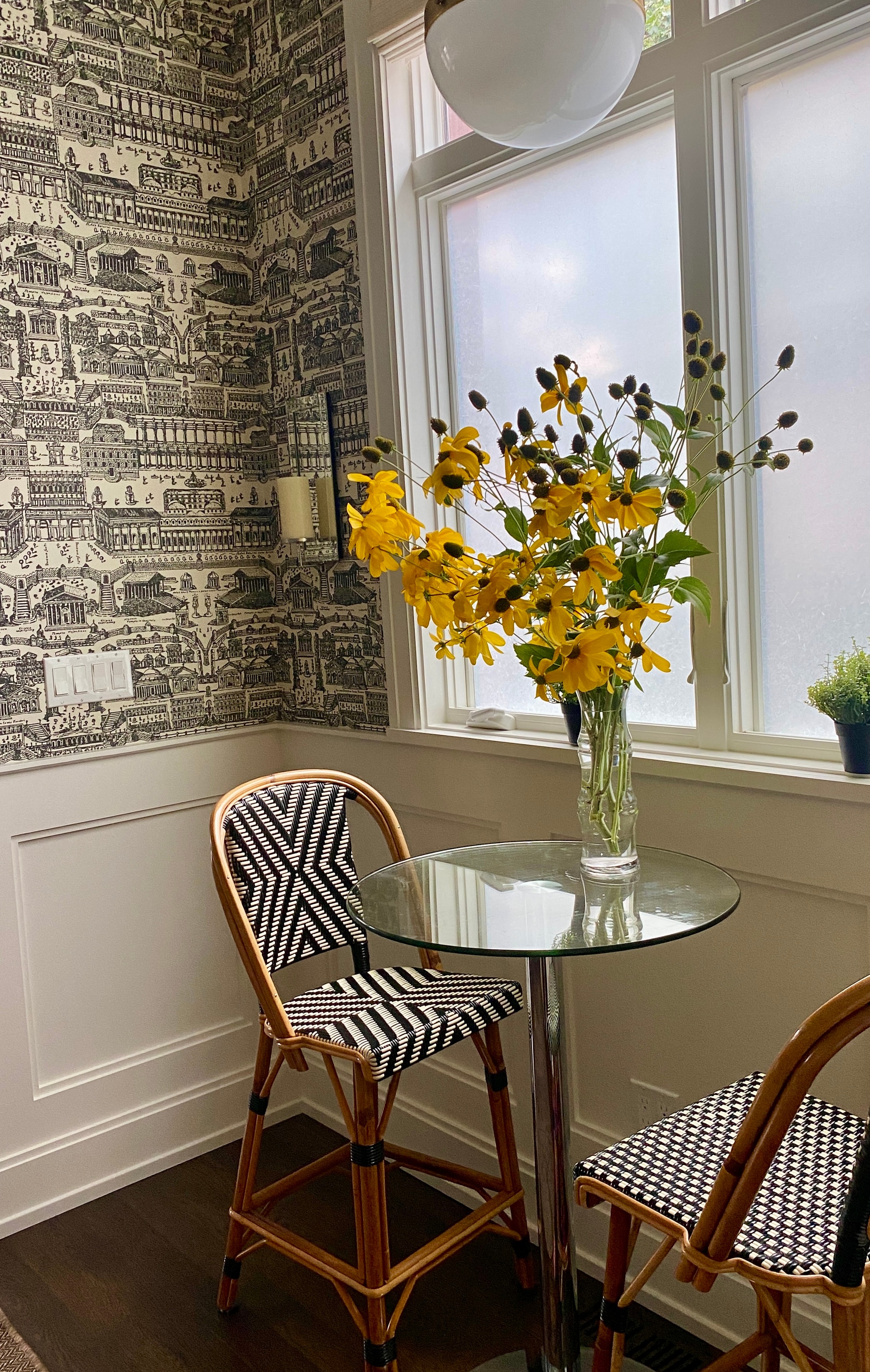 Yellow flowers in a glass vase by the window